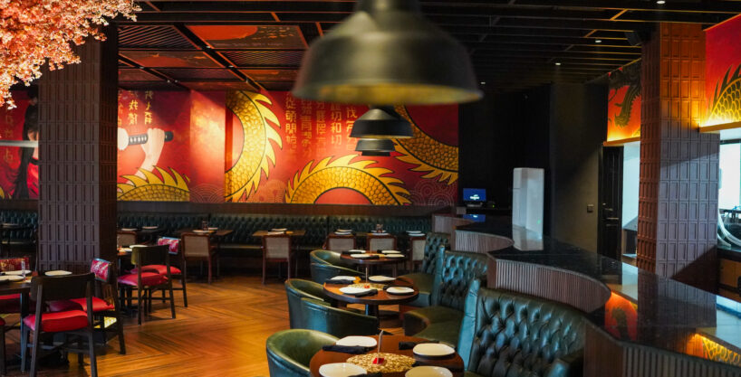 Dining area of P.F. Chang's Islamabad with red and gold dragon wall art and leather booths, fit-out by HAY Builders.